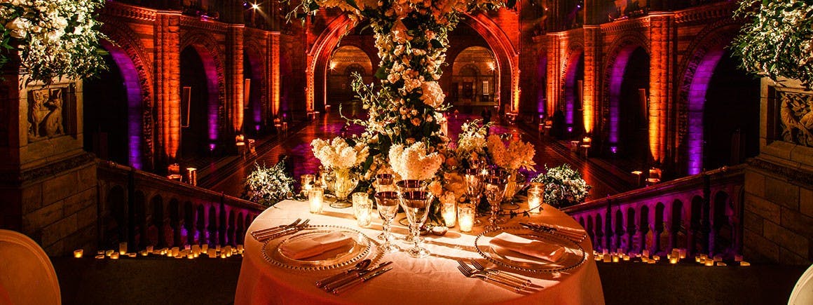 Elegant table setting with floral arrangements at Natural History Museum for upscale events.