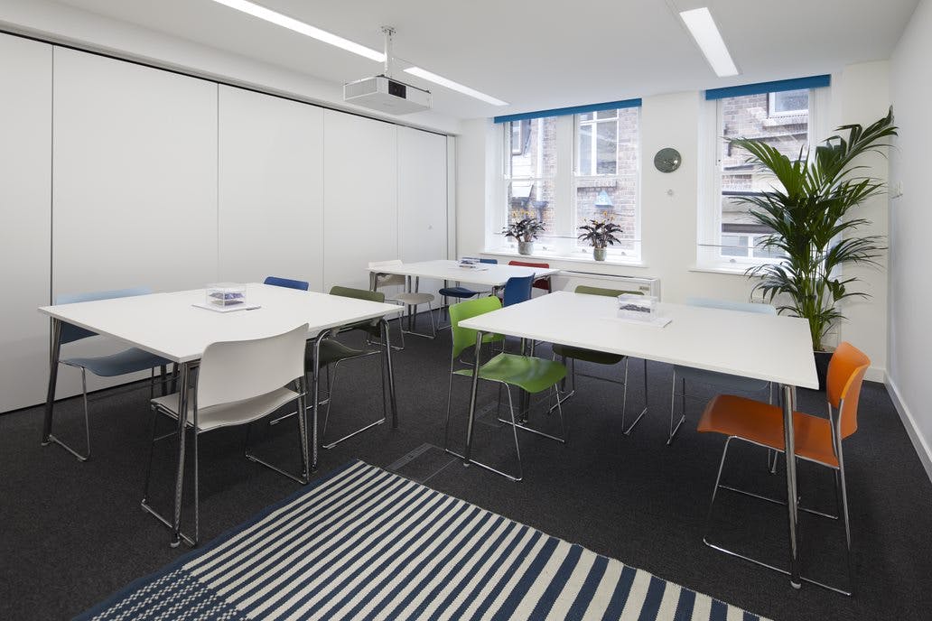 Modern meeting room with colorful chairs, ideal for workshops and brainstorming sessions.