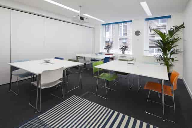 Modern meeting room with colorful chairs, ideal for workshops and brainstorming sessions.