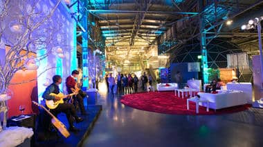Full Buyout event space in Exploratorium, San Francisco, with vibrant lighting and networking.