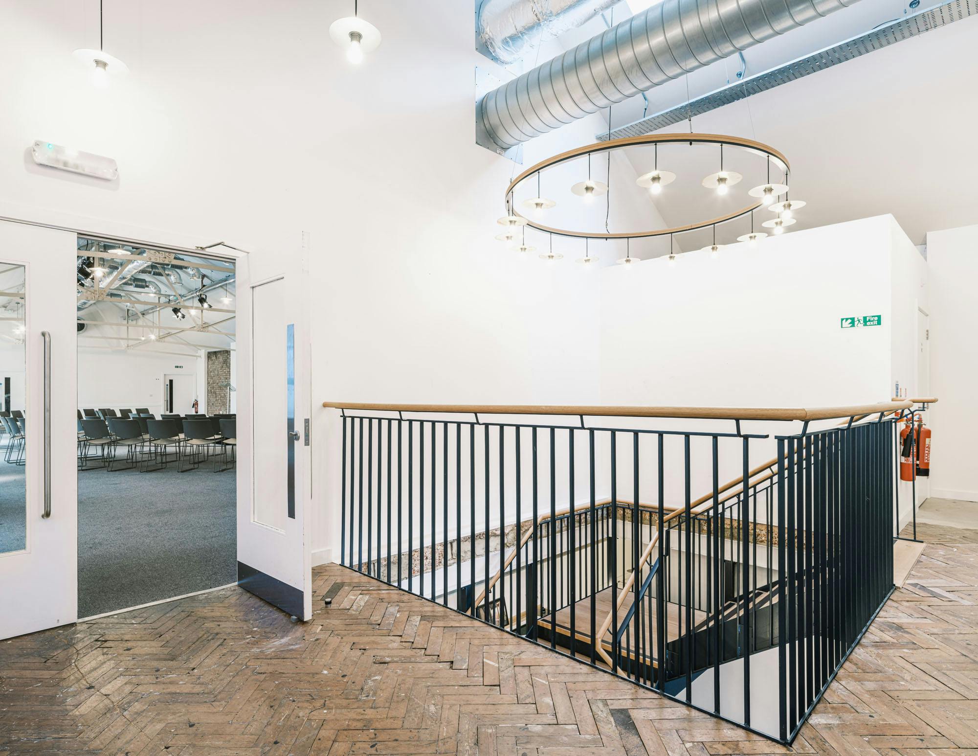 Modern event space with open staircase, ideal for meetings and private dining.