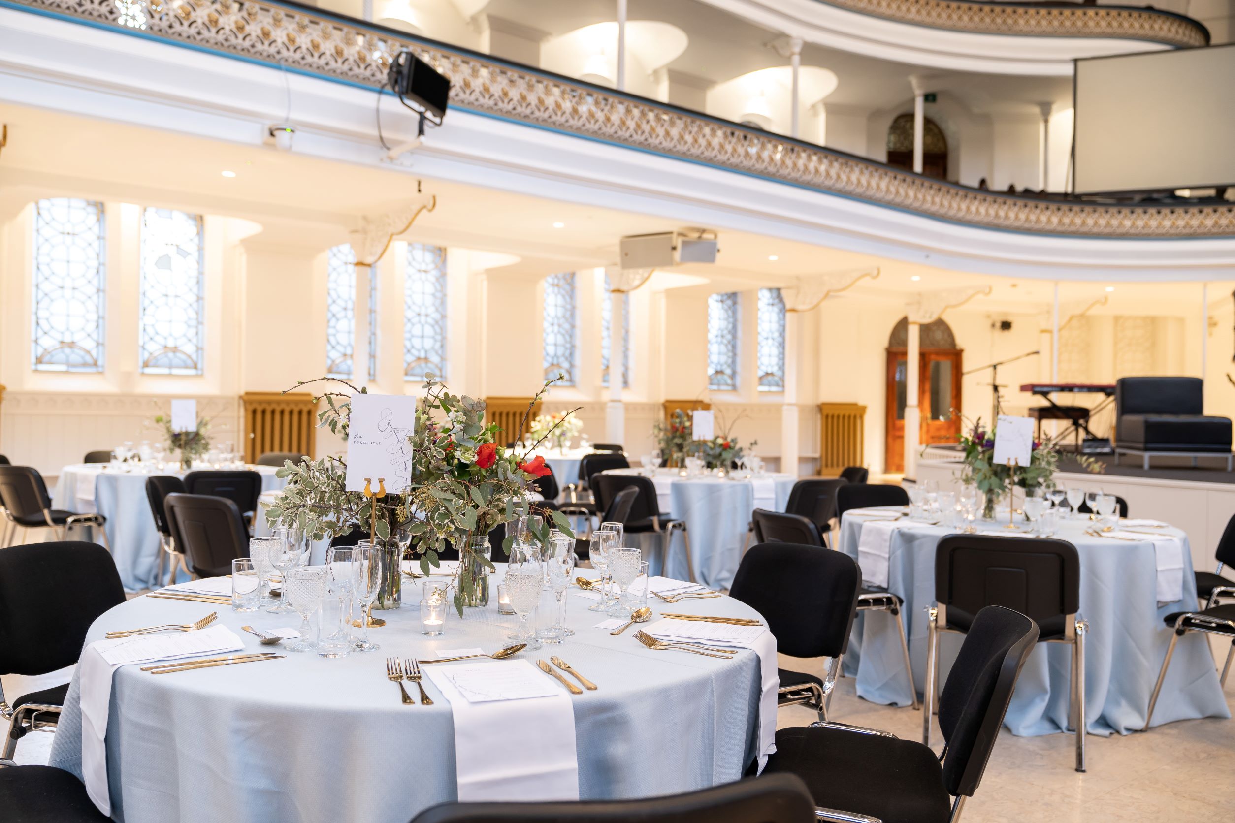 Elegant event space in Westminster Chapel with light blue tables for banquets and corporate events. - Banner
