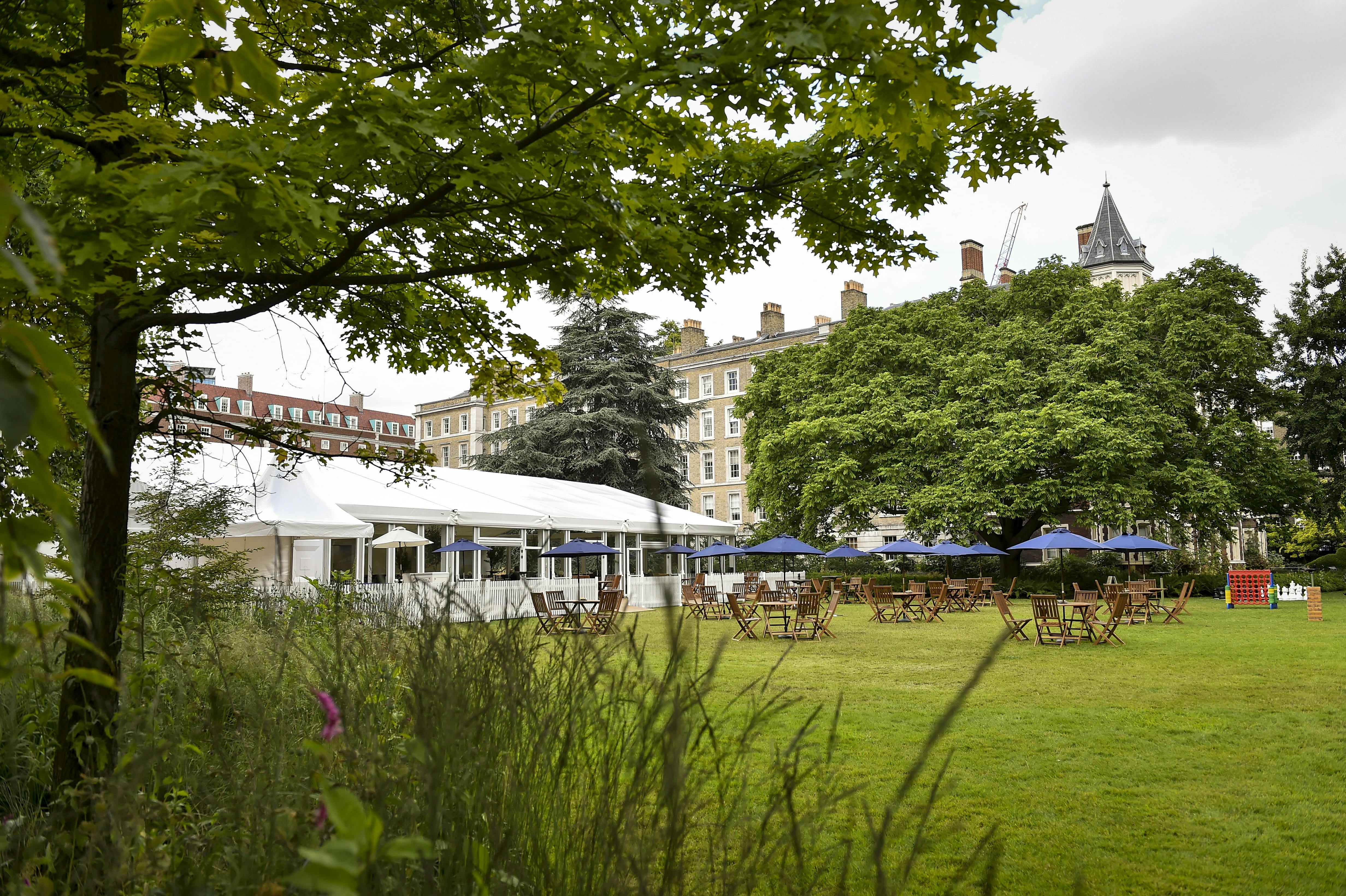 Spacious Garden Marquee venue for events, surrounded by lush greenery and elegant architecture.