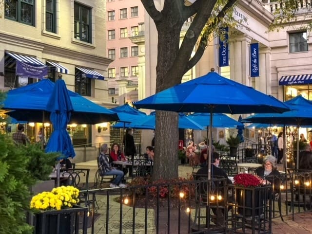 Outdoor dining area with blue umbrellas for casual networking events in Wunder Garten.