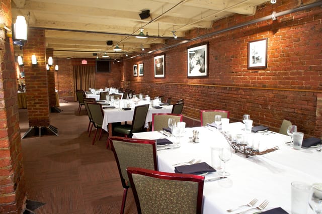Brewer's Lounge dining space with warm brick walls, ideal for corporate events and gatherings.