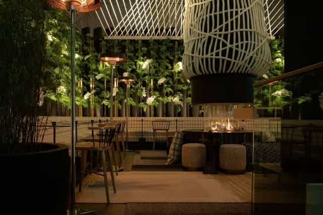 Izakaya Lounge bar area with lush greenery, perfect for upscale events and gatherings.