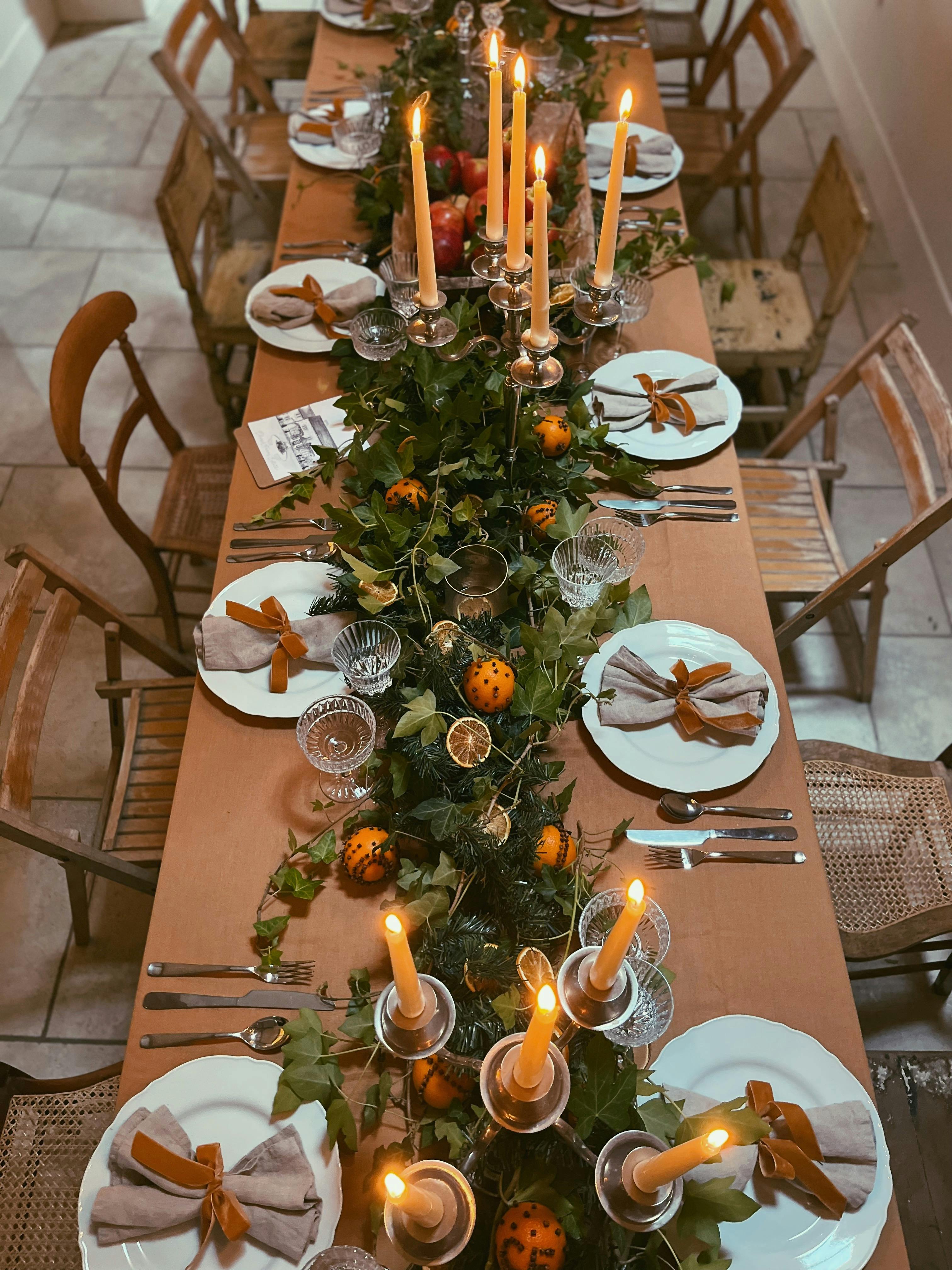 Elegant dining table with lush greenery, perfect for festive gatherings and holiday events.