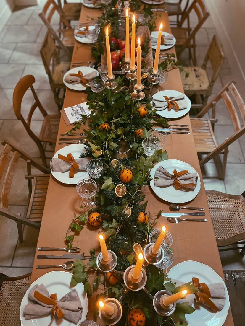 Elegant dining table with lush greenery, perfect for festive gatherings and holiday events.