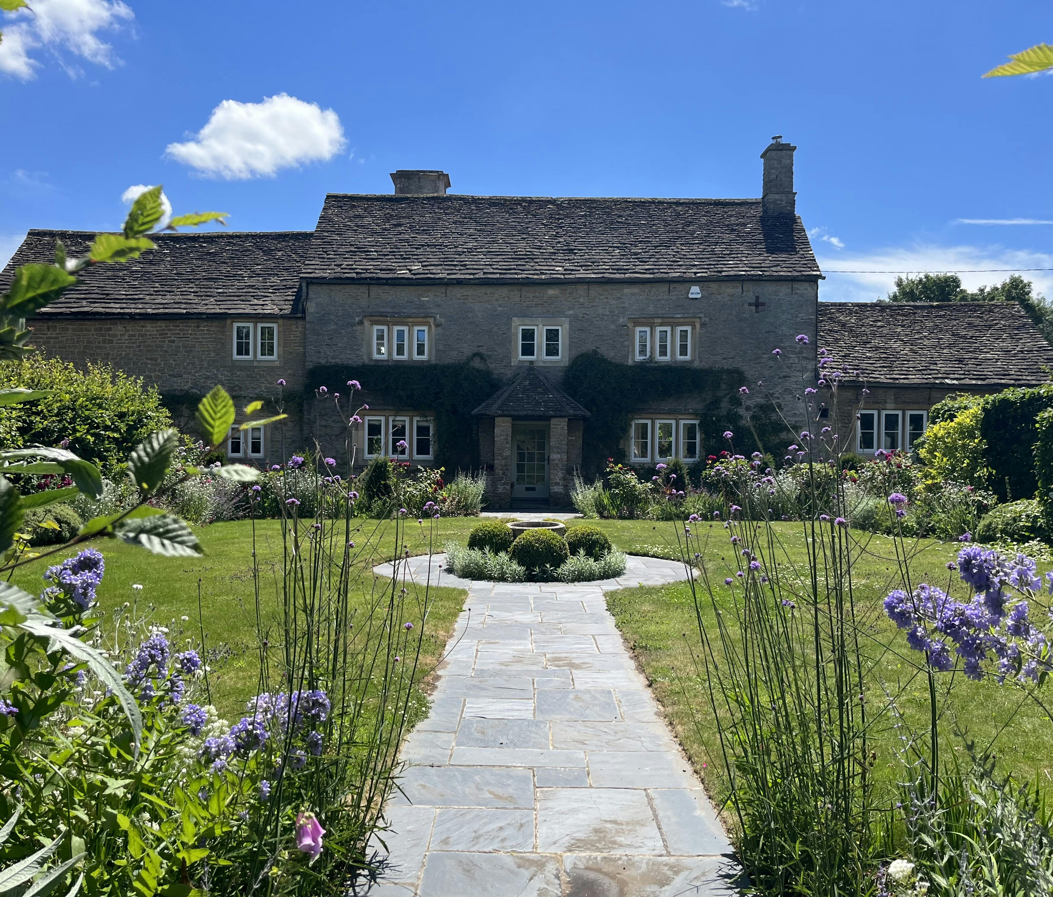 Charming stone farmhouse venue for weddings and outdoor events in lush gardens.