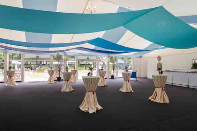 Marquee garden venue for corporate networking reception with elegant ceiling draping.