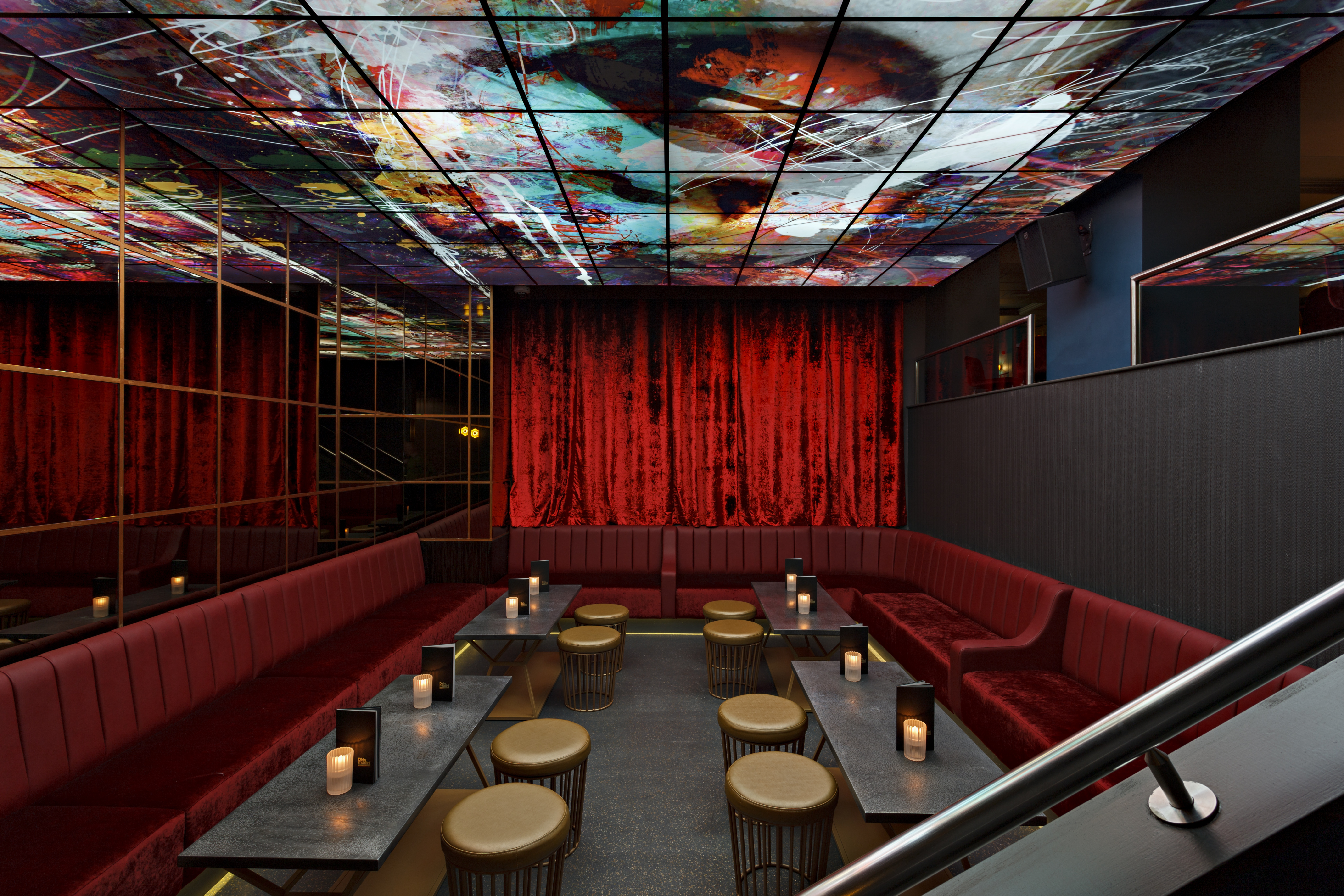 Stylish event space at The Martini Den with plush red seating, ideal for gatherings. - Banner