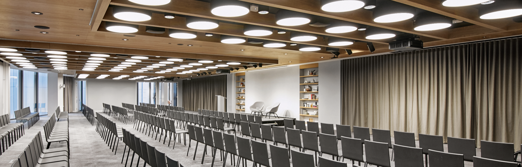 Modern event space with minimalist stage for corporate meetings and conferences. - Banner
