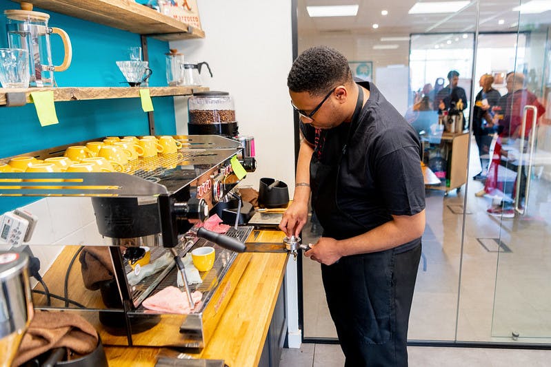Barista preparing coffee in a vibrant training room for an engaging event.