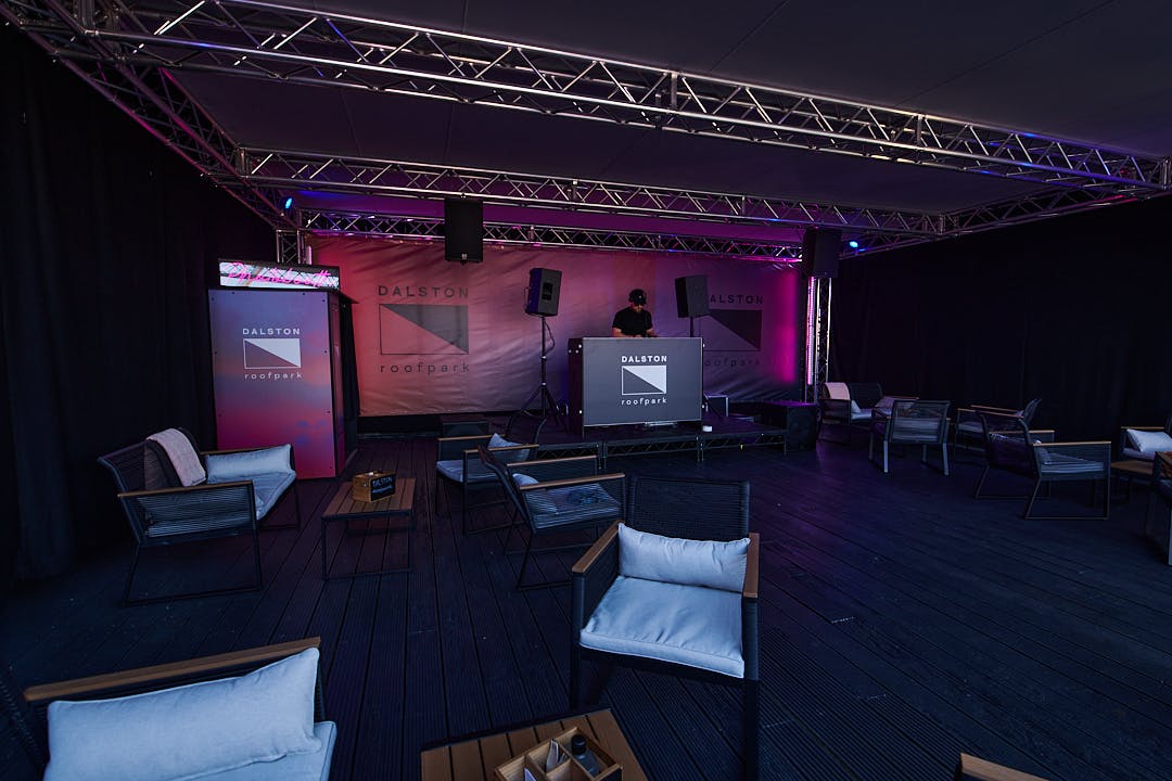 Dalston Roofpark rooftop event space with DJ booth and modern lounge seating.
