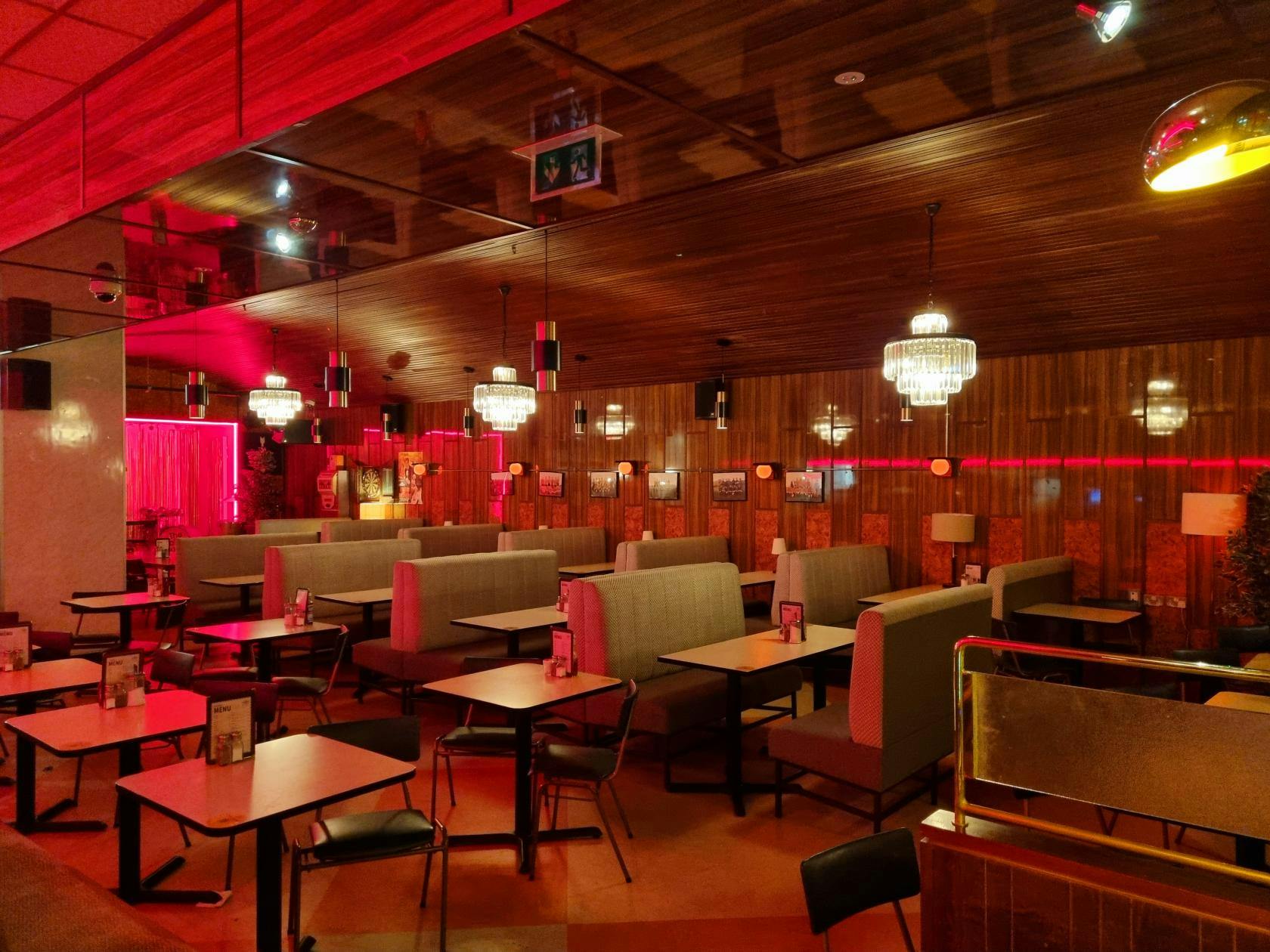 Retro event space with cozy booths, ideal for intimate gatherings and themed events.