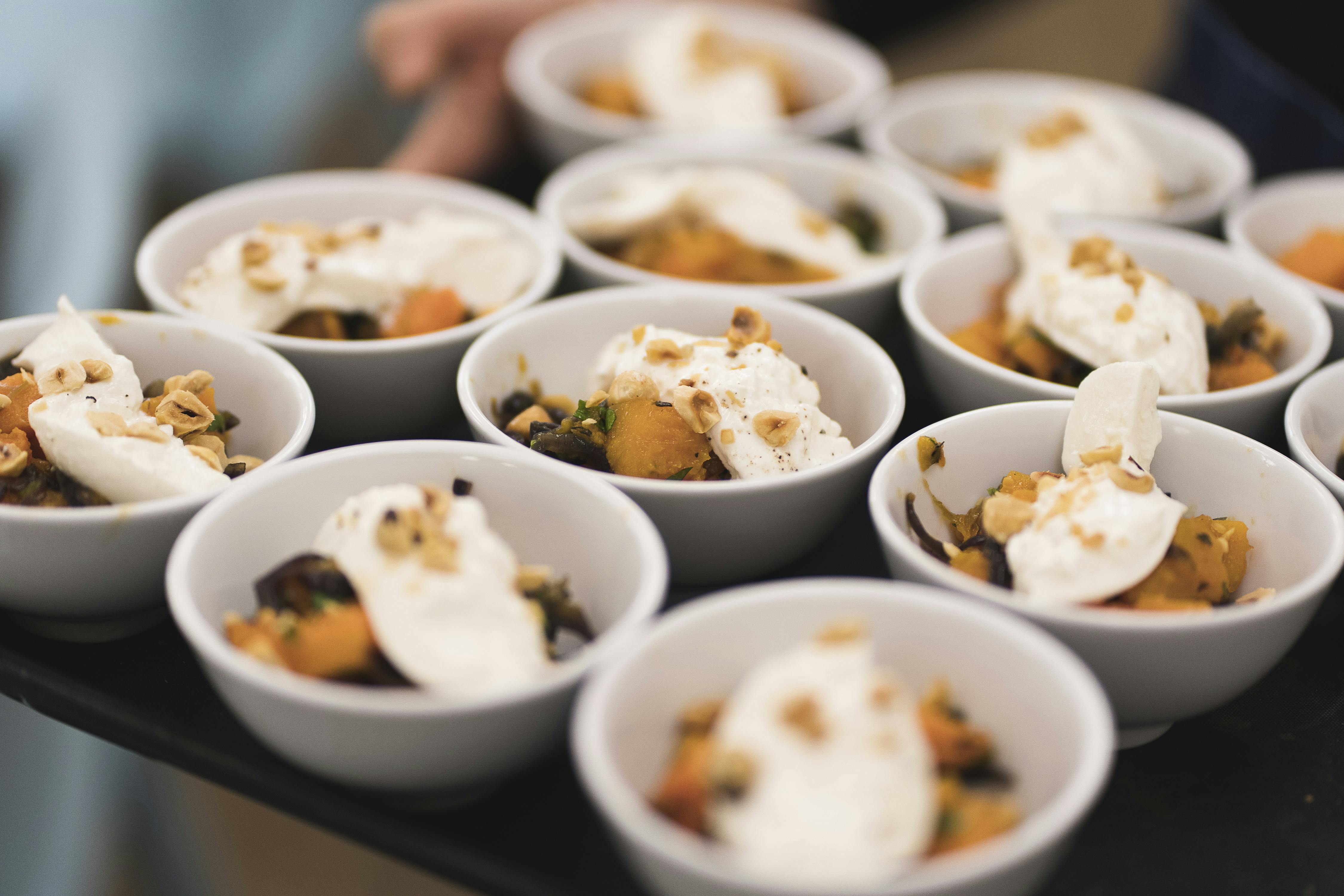 Dessert cups with whipped cream and nuts at Clerkenwell Kitchen for upscale events.