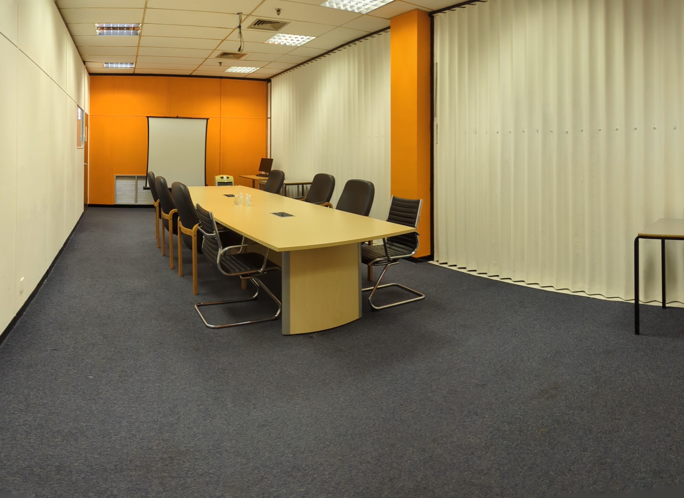 Modern boardroom with oval table, ergonomic chairs for meetings and brainstorming.