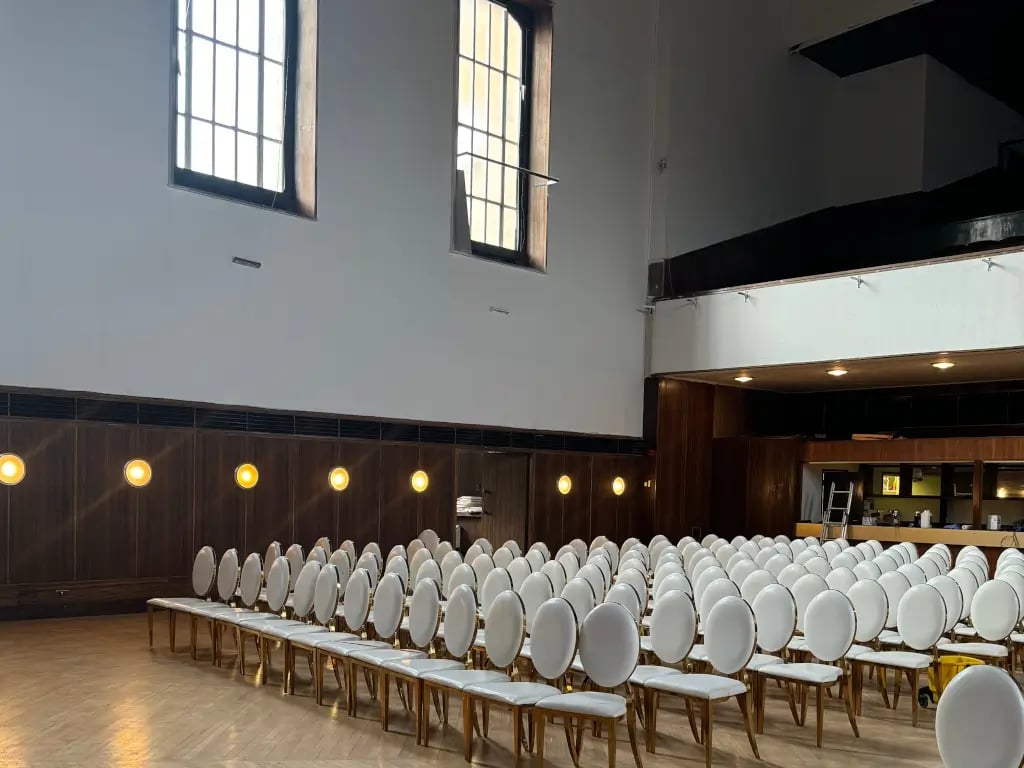 Open plan theater-style venue at EH Woolwich with wood paneling for corporate presentations.
