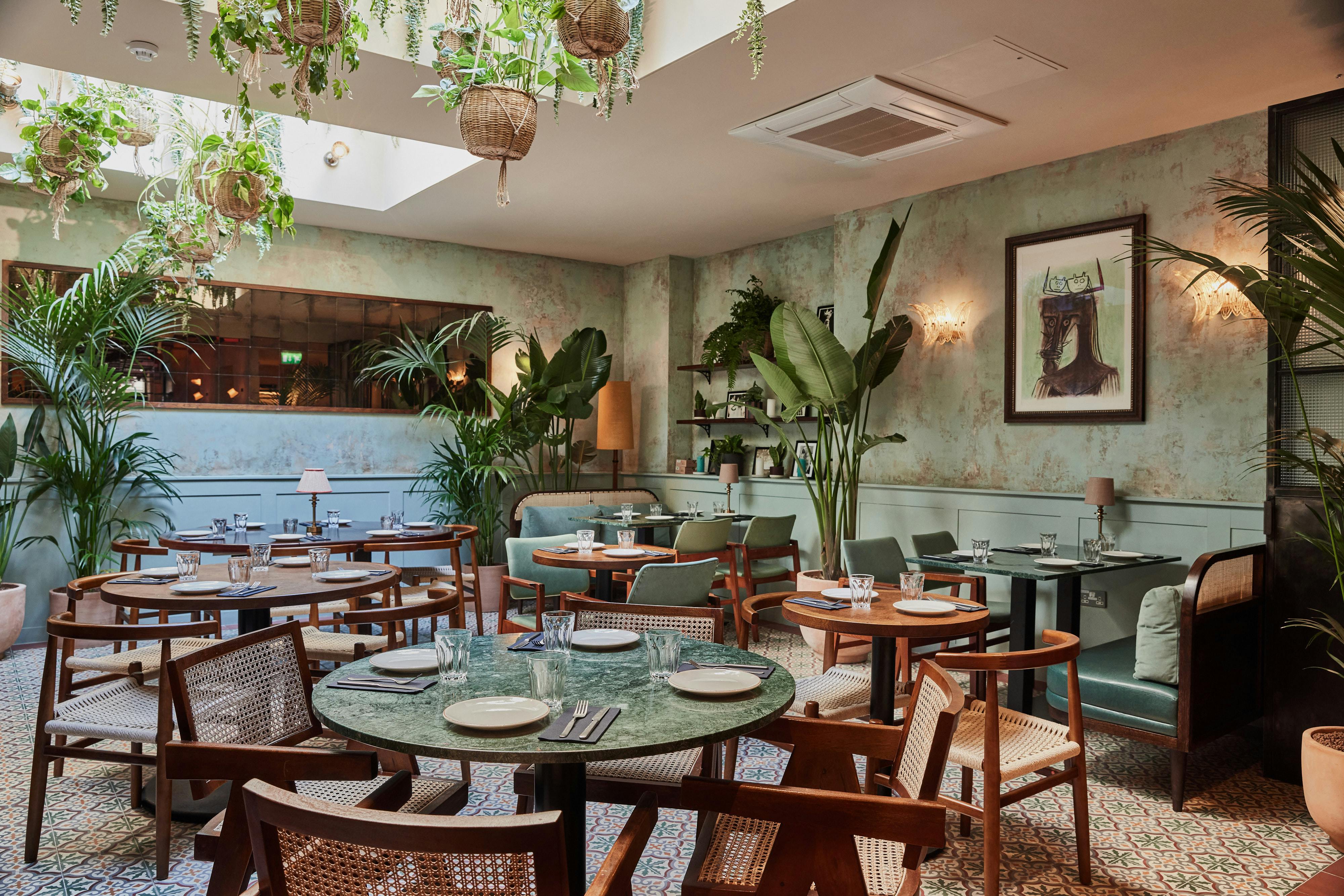 Stylish Palm Room restaurant with lush greenery, perfect for intimate events and meetings.