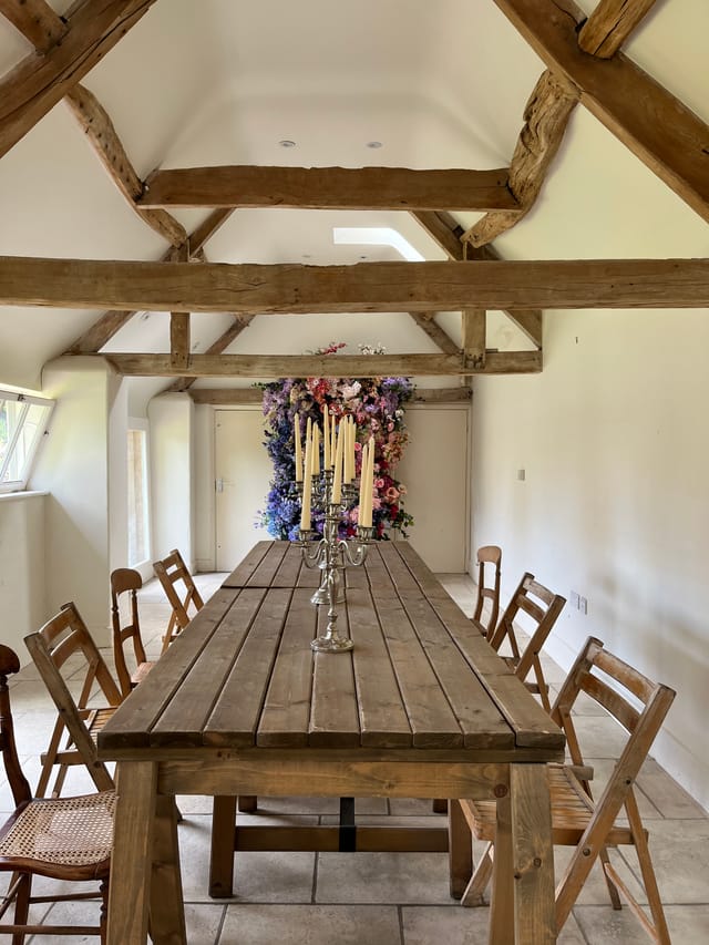 Rustic wooden table with candles in a charming meeting space for workshops and gatherings.