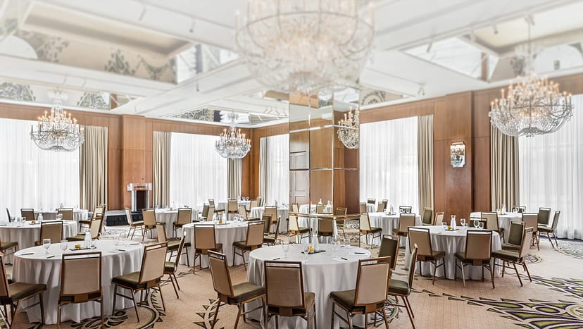 Elegant event space with round tables and chandeliers at Omni Mont-Royal.