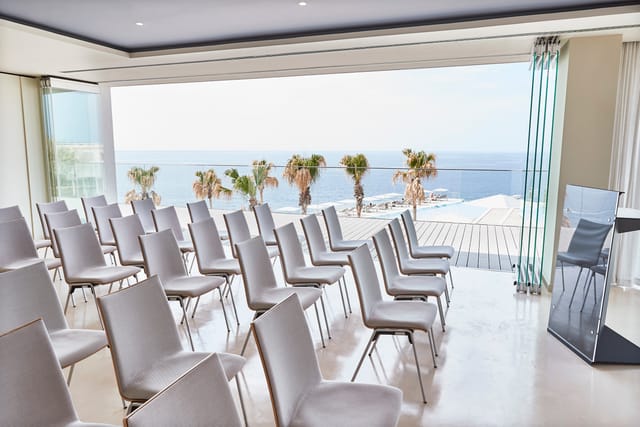 Es Vedra event space at 7Pines Resort Ibiza with ocean view and white chairs.