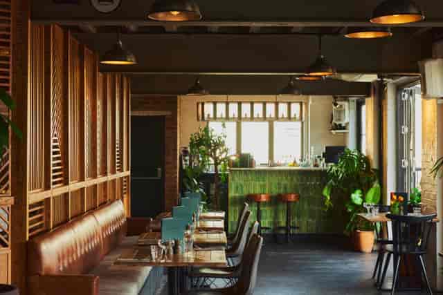 The Mezzanine at The Exhibit Balham: intimate networking venue with lush greenery.