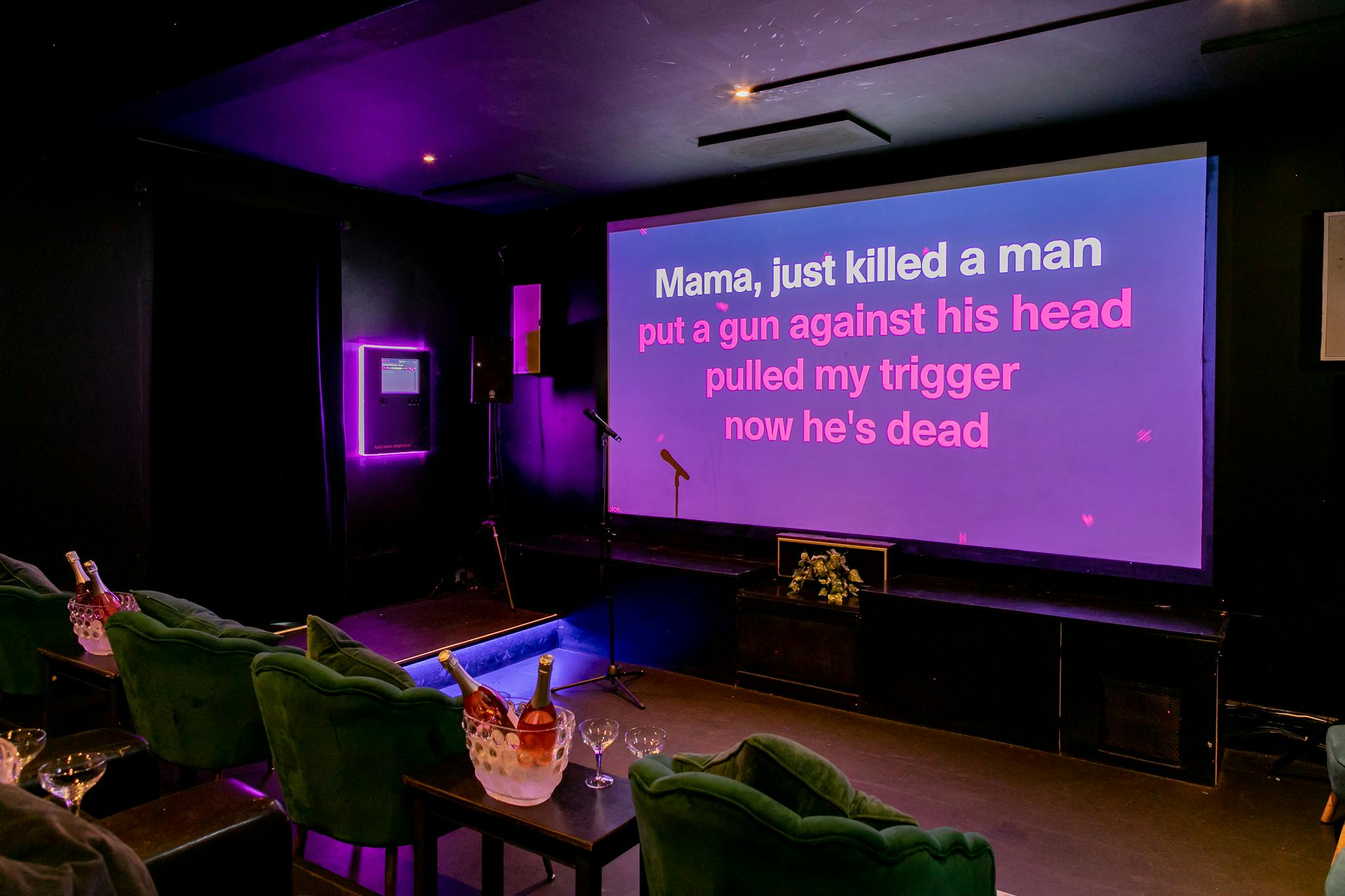 Karaoke night in vibrant event space with large screen and purple lighting at The Exhibit Balham.