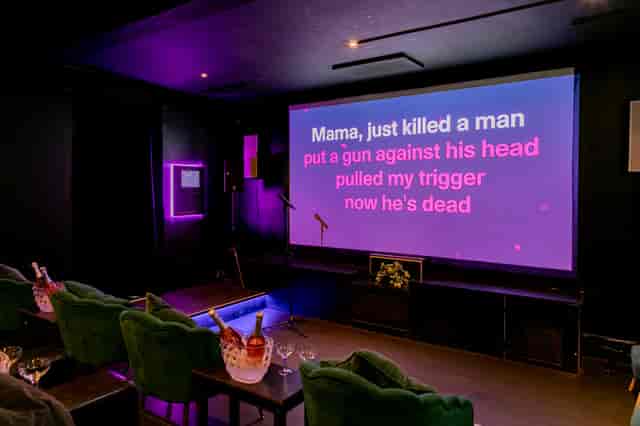 Karaoke night in vibrant event space with large screen and purple lighting at The Exhibit Balham.
