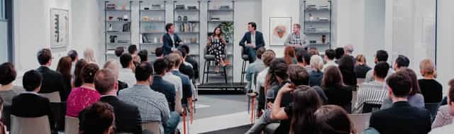 "Panel discussion at Grand Central Lounge with engaged audience and modern decor."