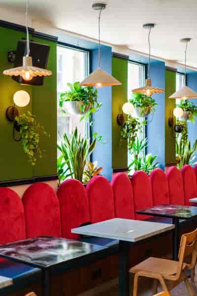Vibrant meeting space with plush red seating at Selina UK Power Plant for networking events.