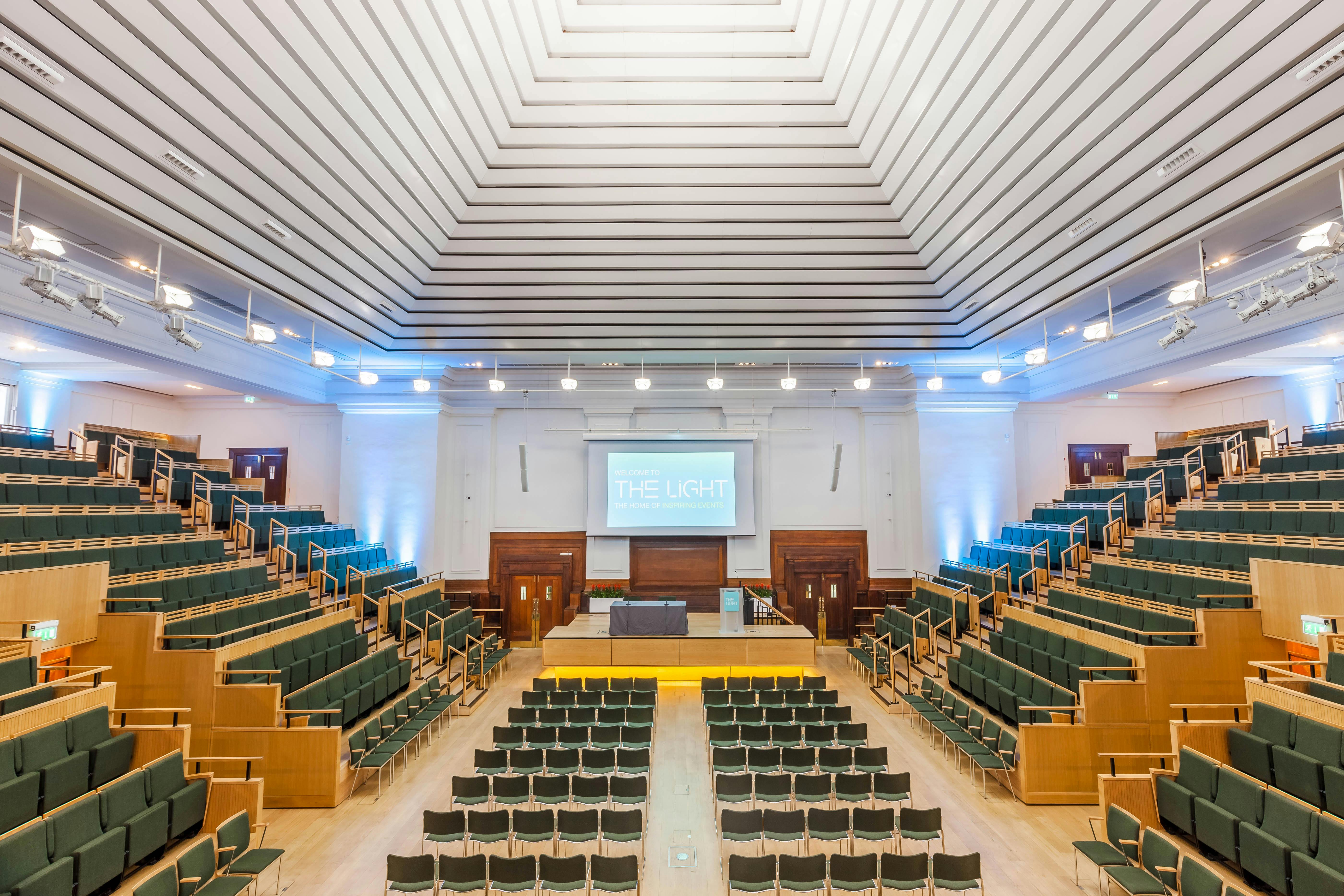 Spacious auditorium with tiered seating for conferences and lectures at Friends House.