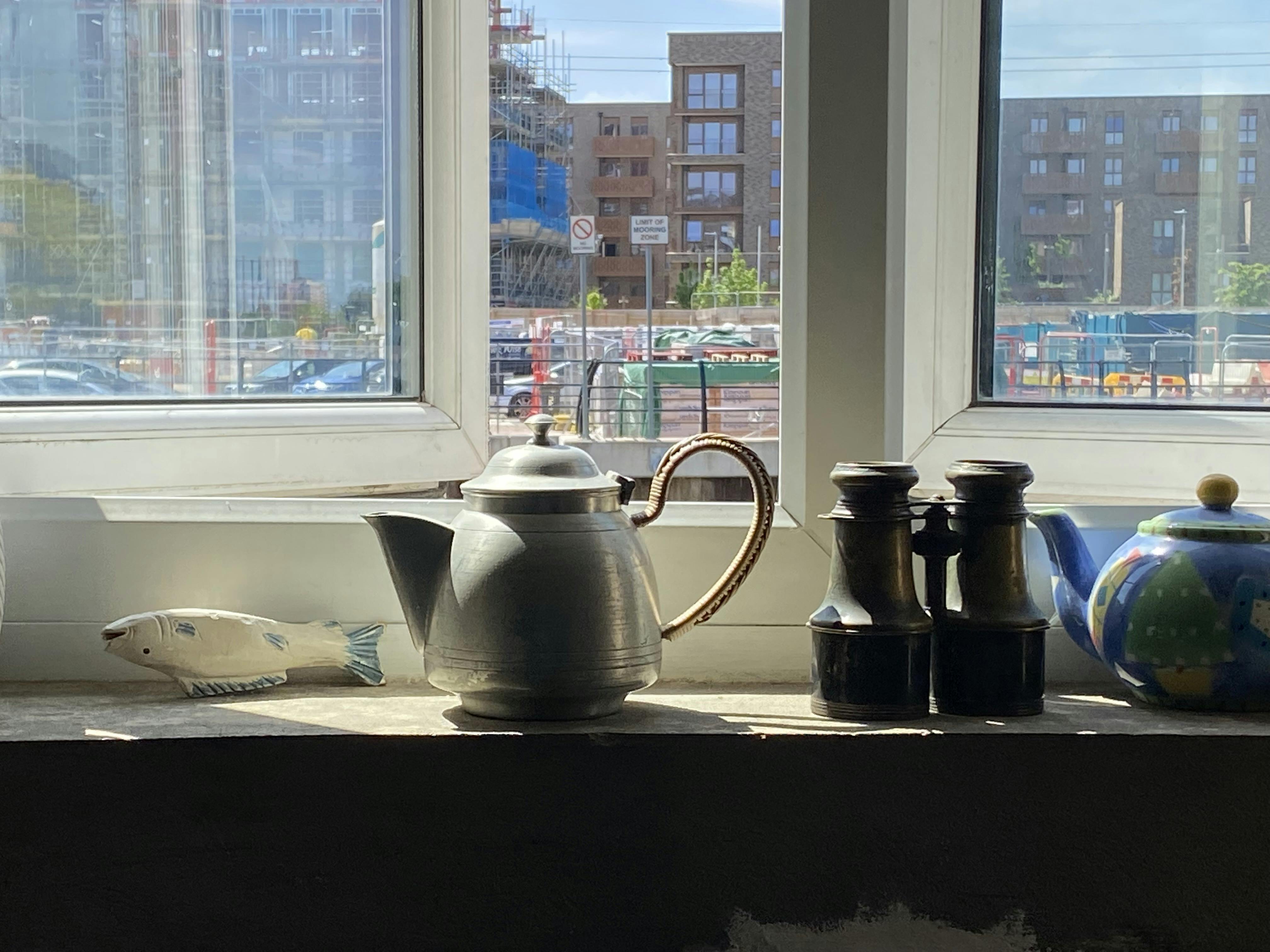 Vintage teapot window display at The Barge Aground, ideal for events and networking.