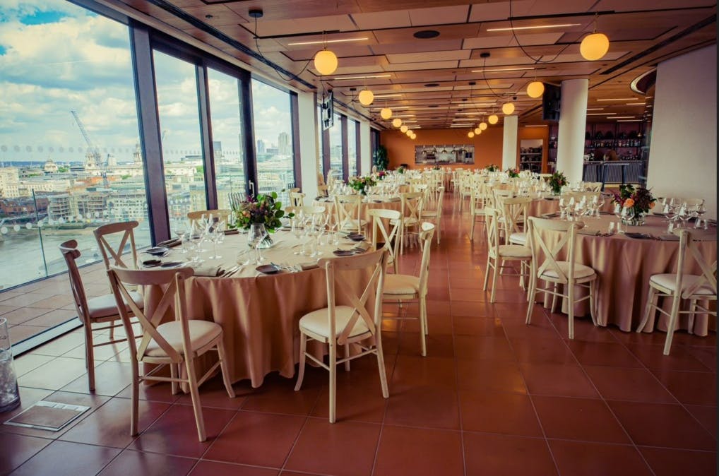 Sophisticated event space with round tables and natural light for corporate meetings.