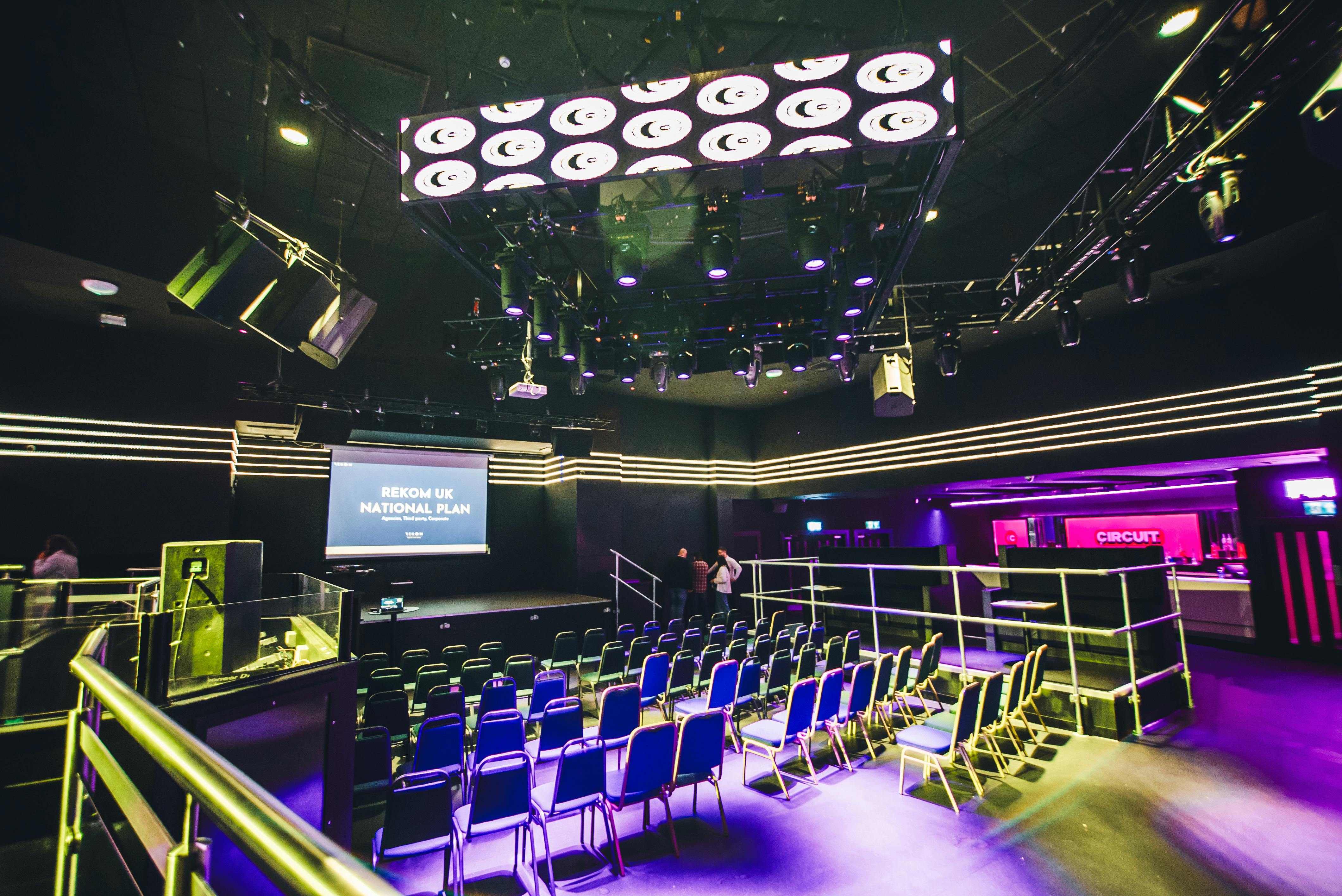 Modern event space with tiered seating, ideal for conferences and performances.