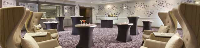 Sophisticated event space with cocktail tables and stylish bar in Hyatt Place Montreal.