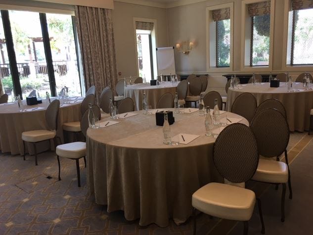Jawharah Room at Four Seasons Dubai, round tables set for meetings and workshops.