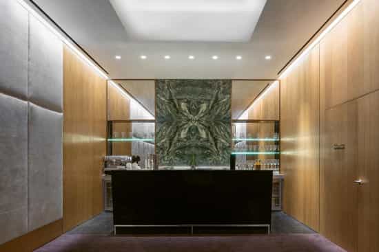Sleek bar area with green marble wall in Bulgari Hotel Dubai for networking events.