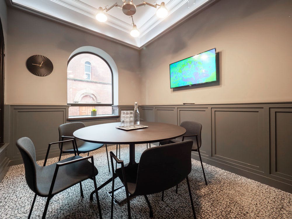 Modern meeting room with round table, ideal for collaborative gatherings and presentations.