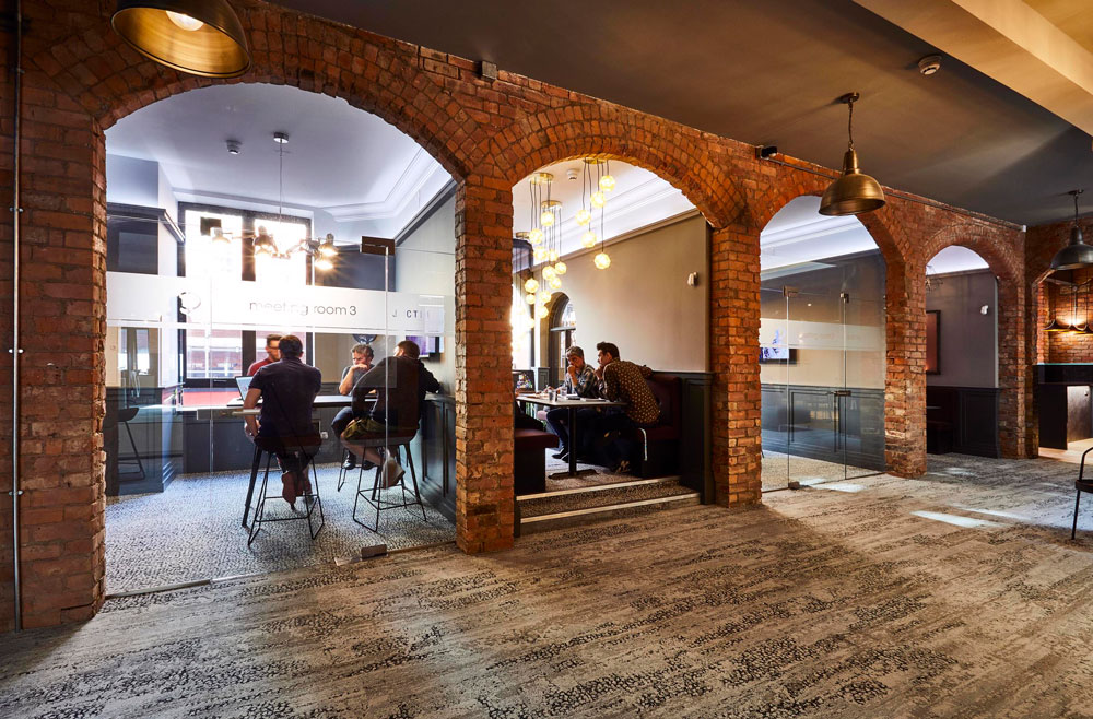 Modern meeting room with exposed brick arches for networking events at Colony Jactin House.