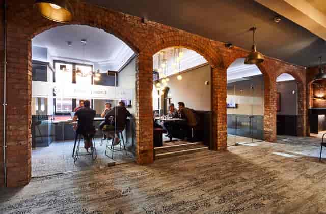 Modern meeting room with exposed brick arches for networking events at Colony Jactin House.