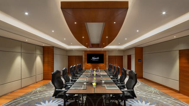 Modern conference room with sleek table setup at Kempinski Hotel for meetings and presentations.