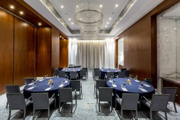 Sophisticated corporate meeting space with navy blue linens in Al Habtoor City Hotel.