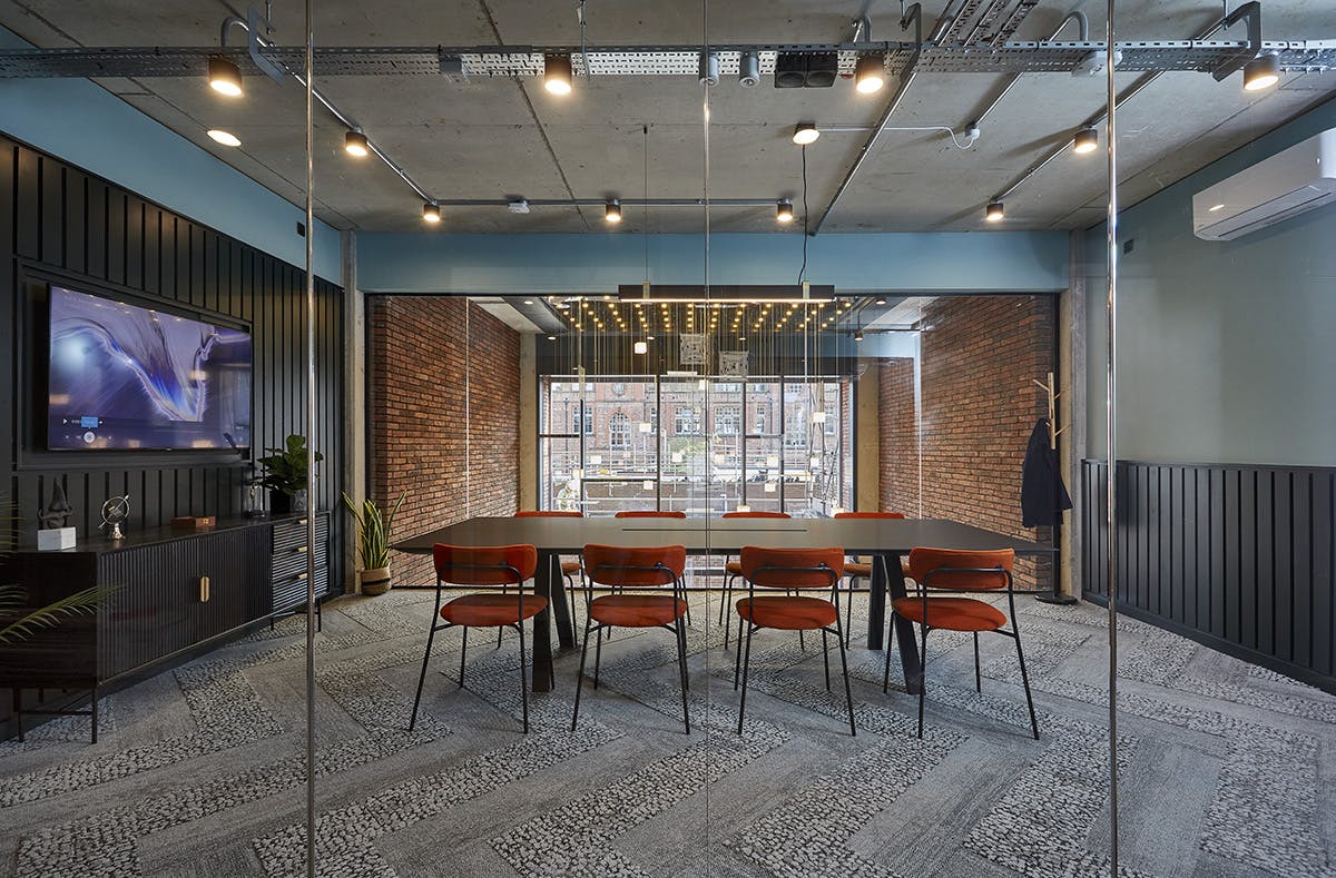 Modern meeting room with large table, natural light for collaborative events.