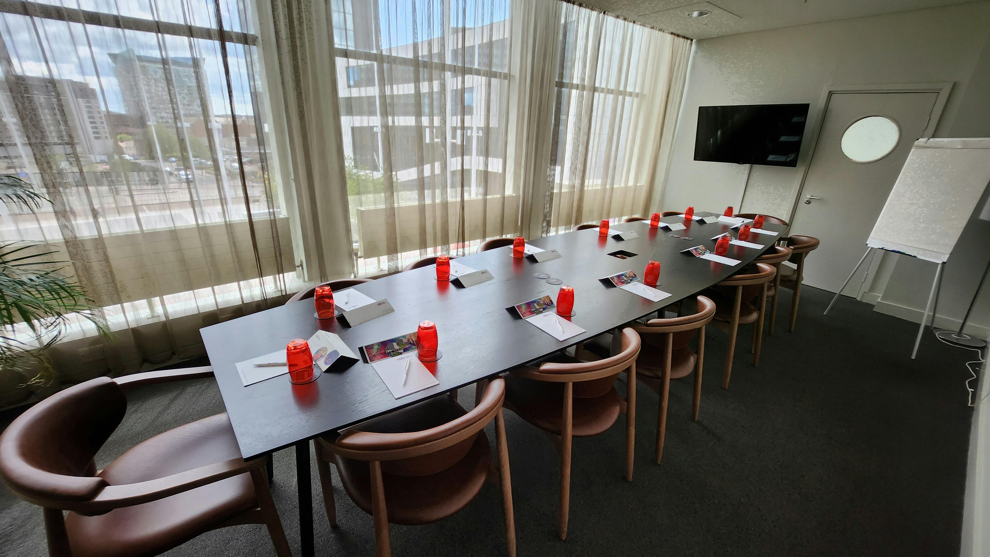 Professional meeting room with long table, notepads, and red centerpieces in Birmingham.