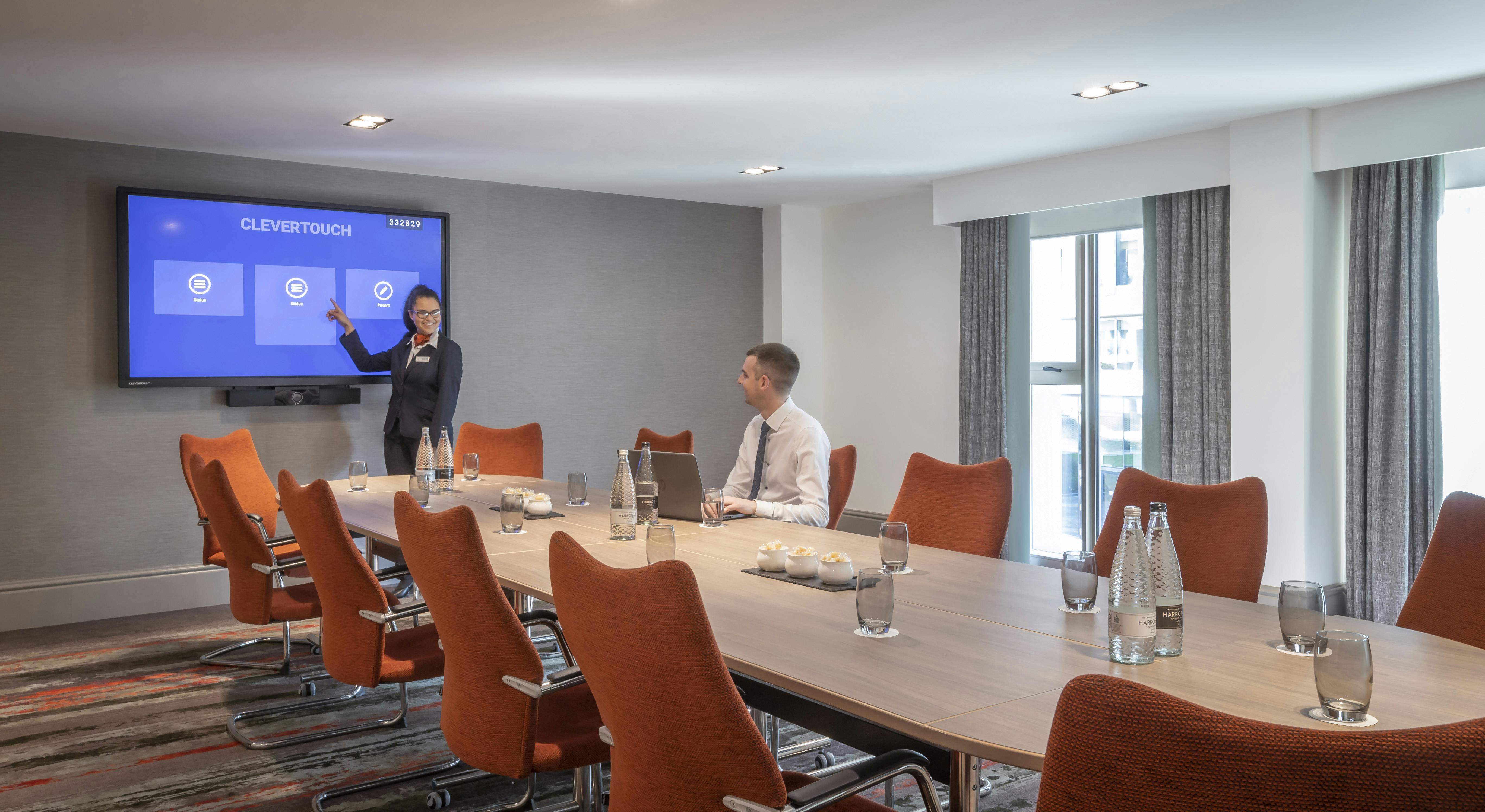 Modern meeting room at Clayton Hotel Cambridge with digital display for presentations.