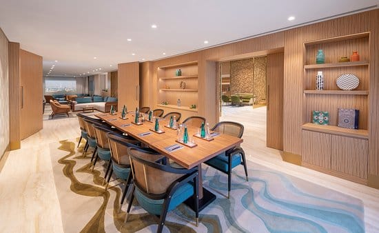 Modern meeting space at Andaz Dubai The Palm with sleek wooden table and natural light.