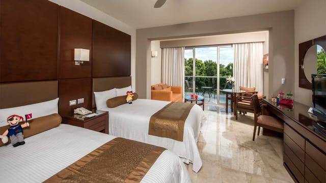 Hotel Grand Riveira Princess bedroom with two beds, ideal for events and relaxation.