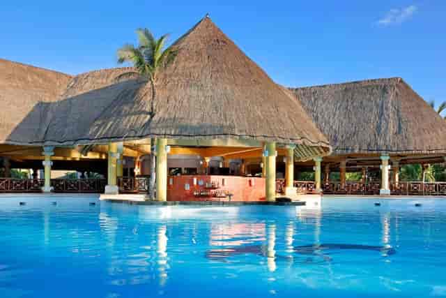 Grand Palladium Kantenah Resort bedroom with thatched roof, ideal for weddings and retreats.