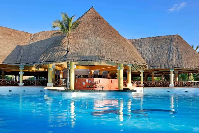 Grand Palladium Kantenah Resort bedroom with thatched roof, ideal for weddings and retreats.